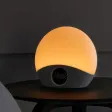Restli Rise väckarklocka med rund ljuskupa som lyser varmt orange och en digital display i den grå textilfoten